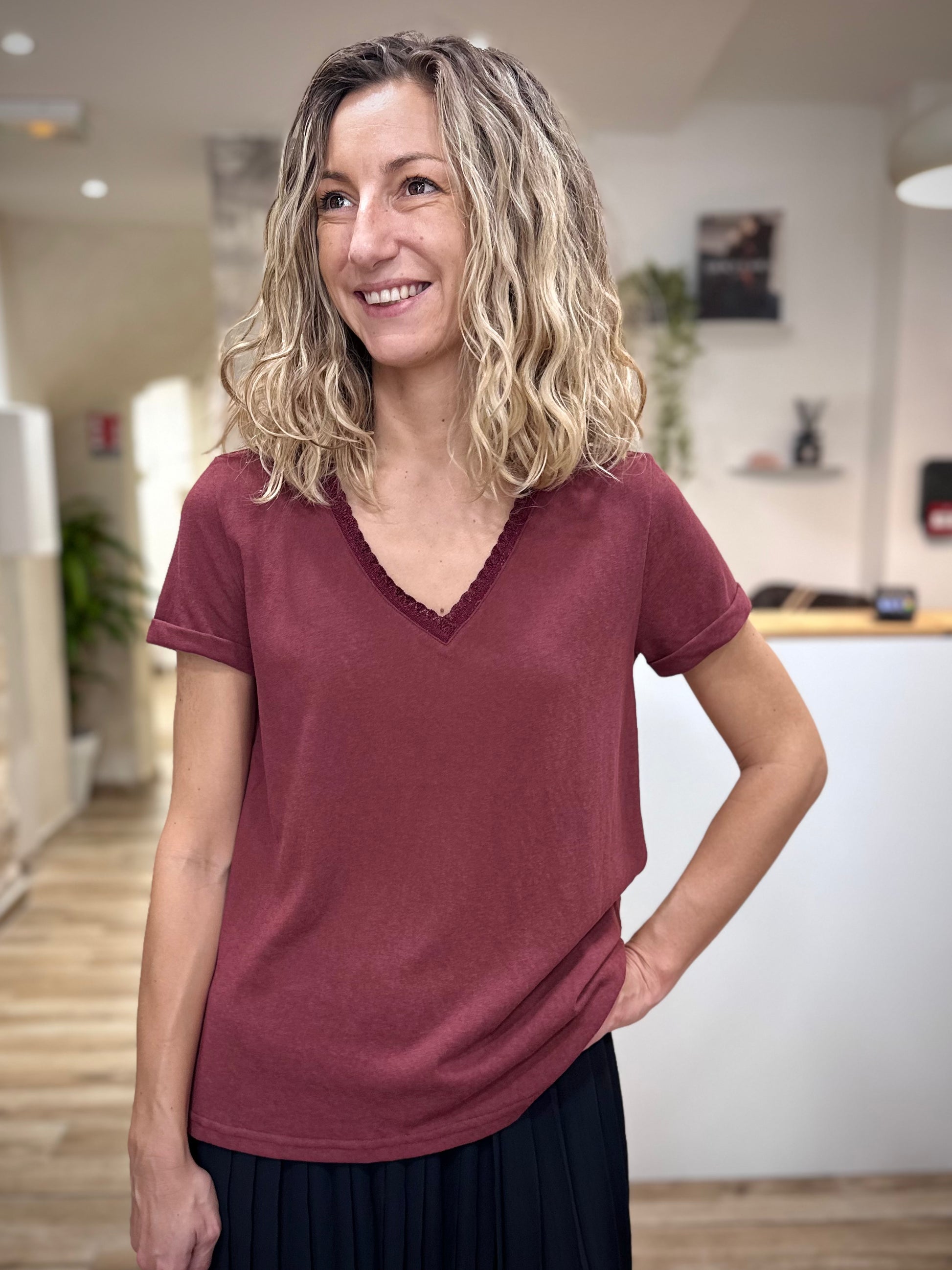 Femme portant un t-shirt bordeaux col V lurex chic