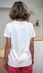 Silhouette féminine de dos portant un tee-shirt blanc épuré 