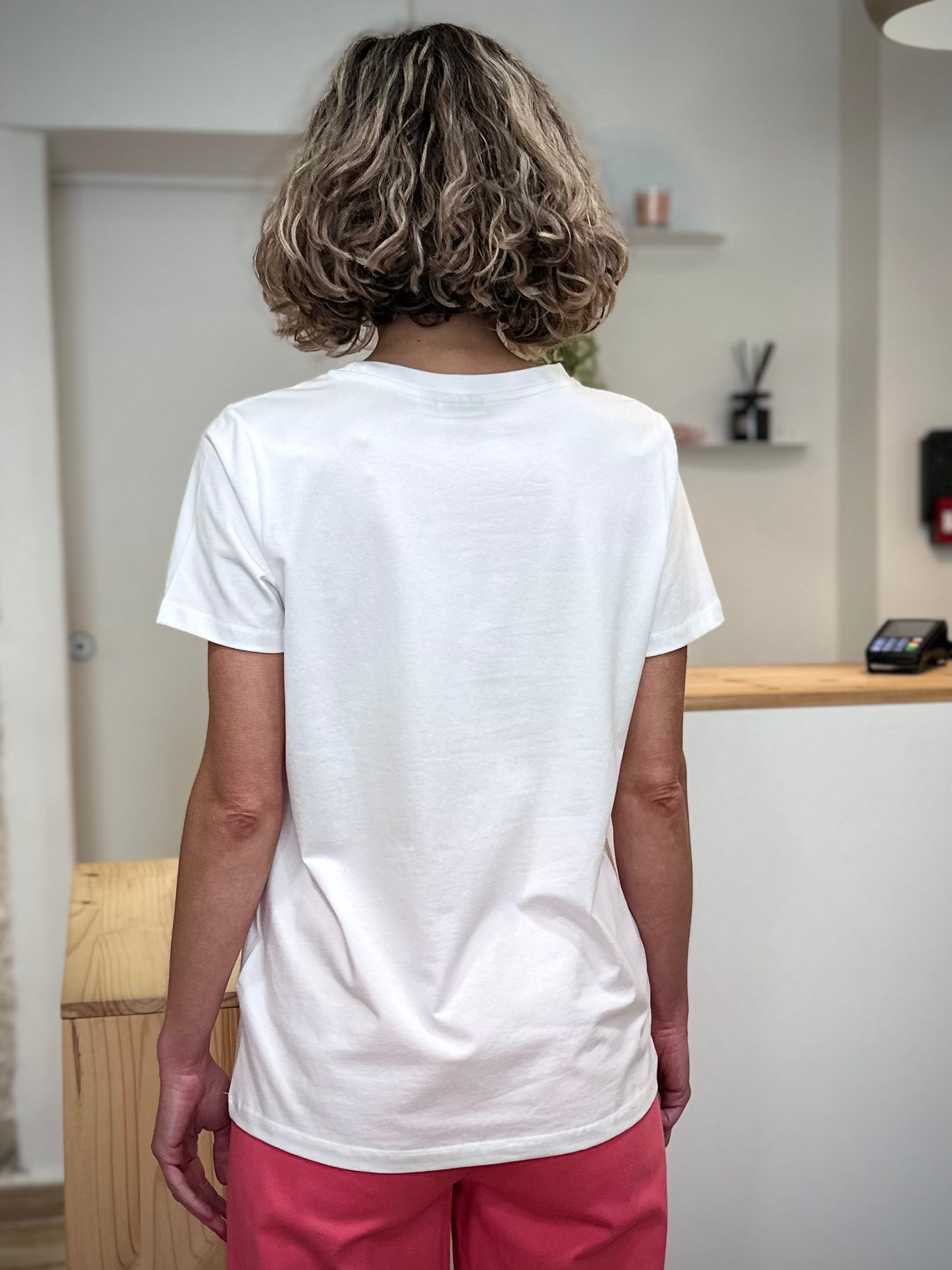 Silhouette féminine de dos portant un tee-shirt blanc épuré 