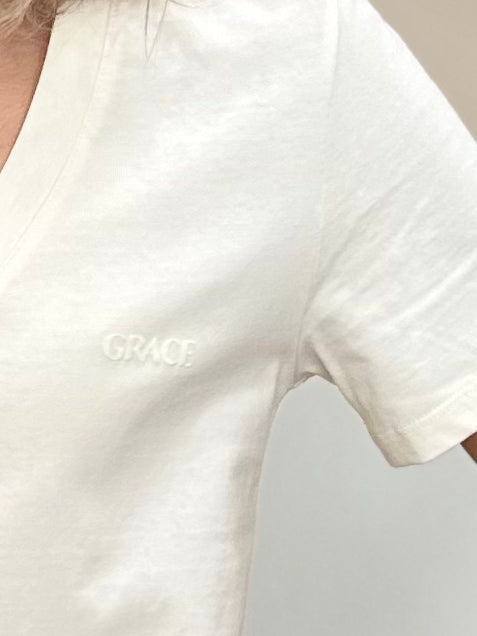 Gros plan sur la broderie « Grace » sur un t-shirt beige
