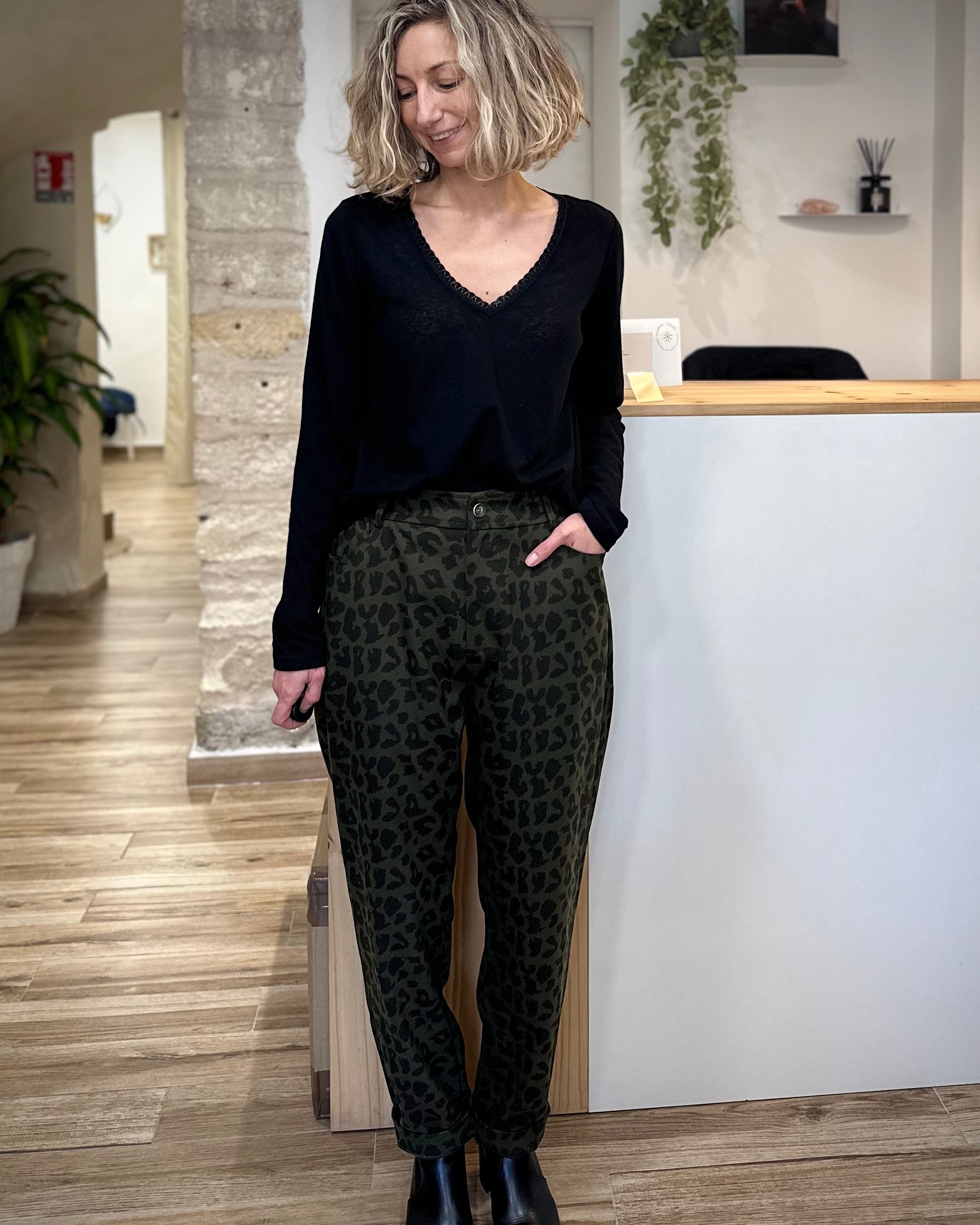 Femme portant un t-shirt noir col V avec liseré lurex