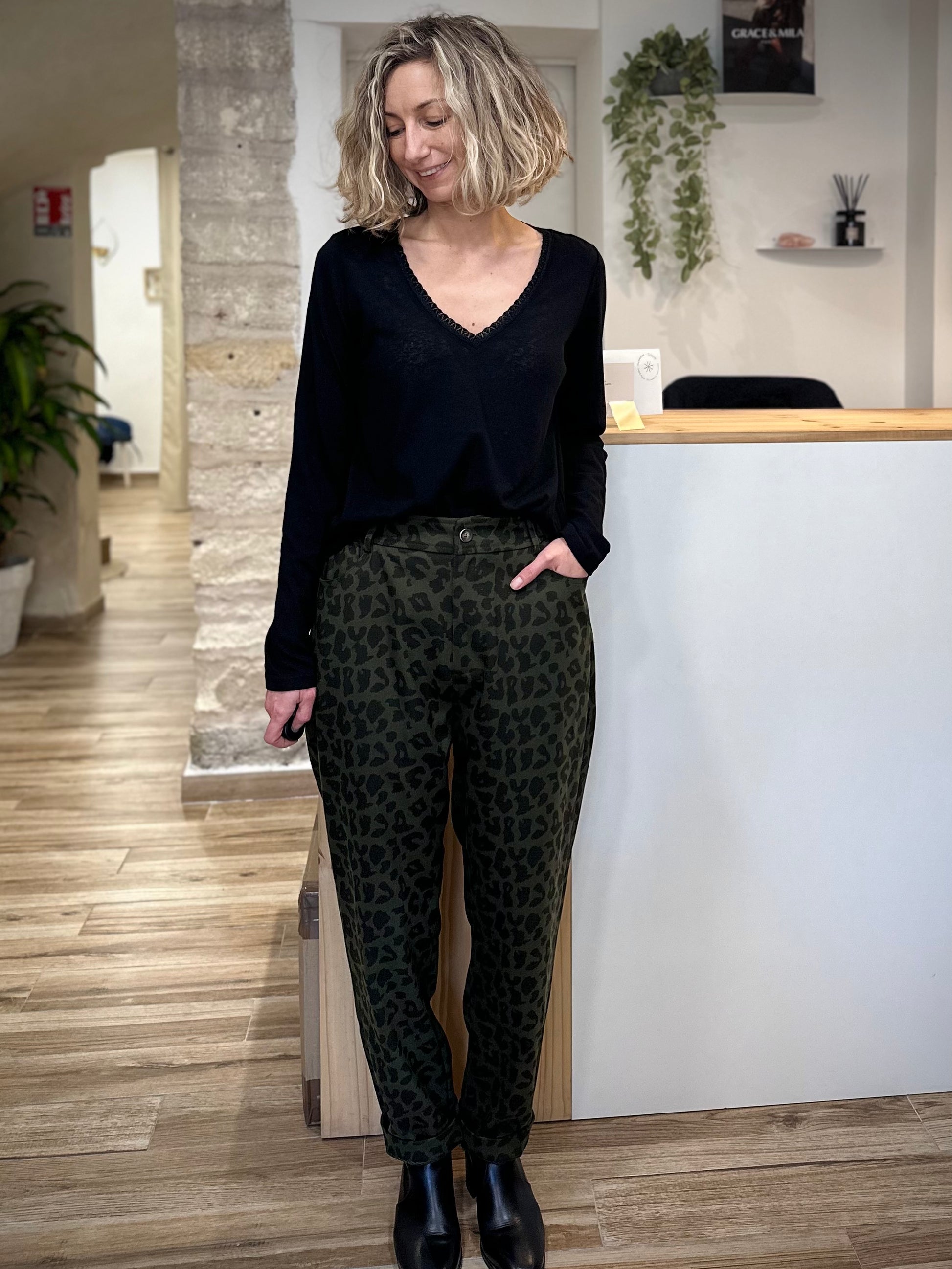 Femme portant un t-shirt noir col V avec liseré lurex