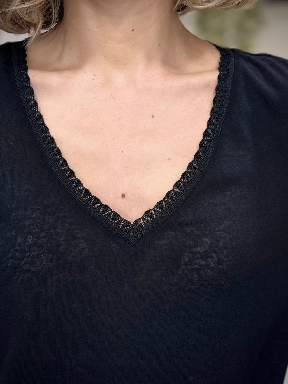 Détail de l’encolure en V bordée de lurex