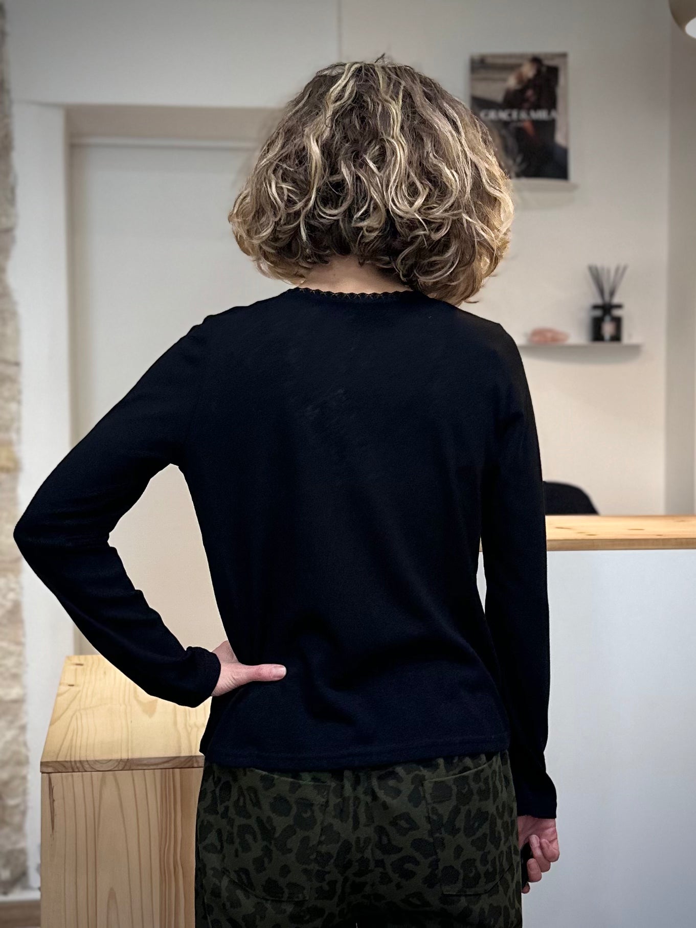 Femme portant un t-shirt noir décolleté V subtil de dos