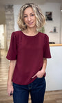 Femme portant un top fluide bordeaux à col rond