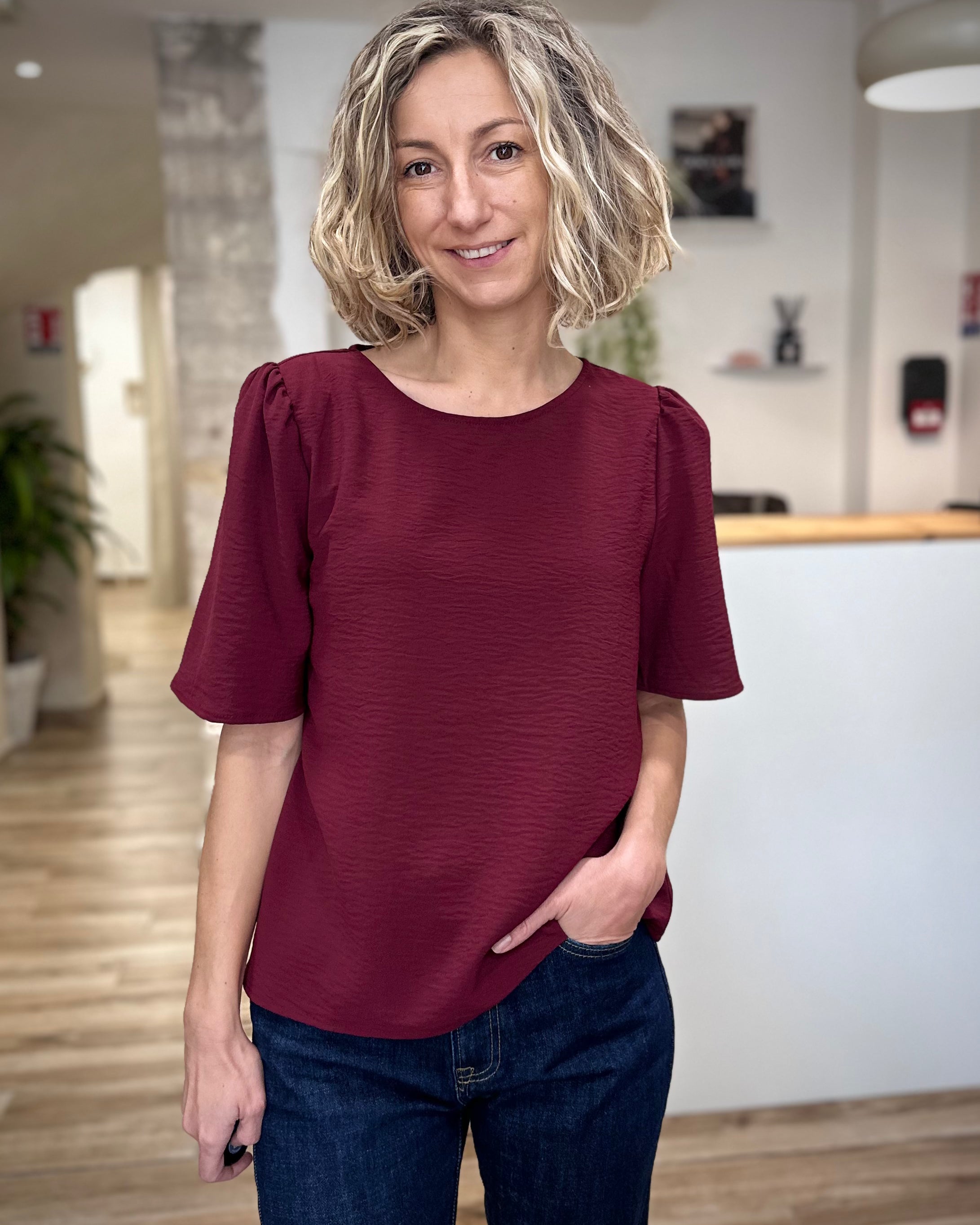Femme portant un top fluide bordeaux à col rond