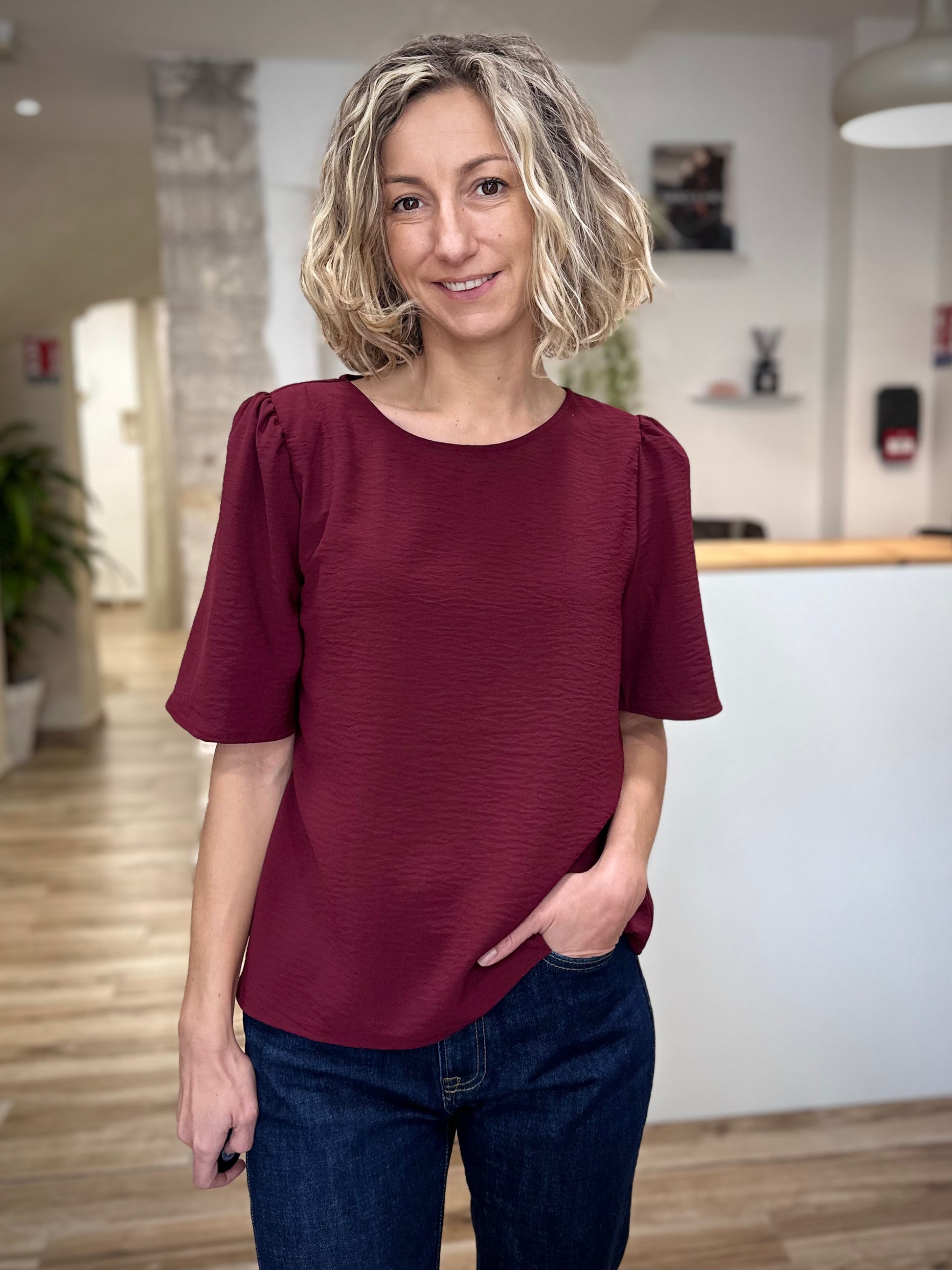 Femme portant un top fluide bordeaux à col rond