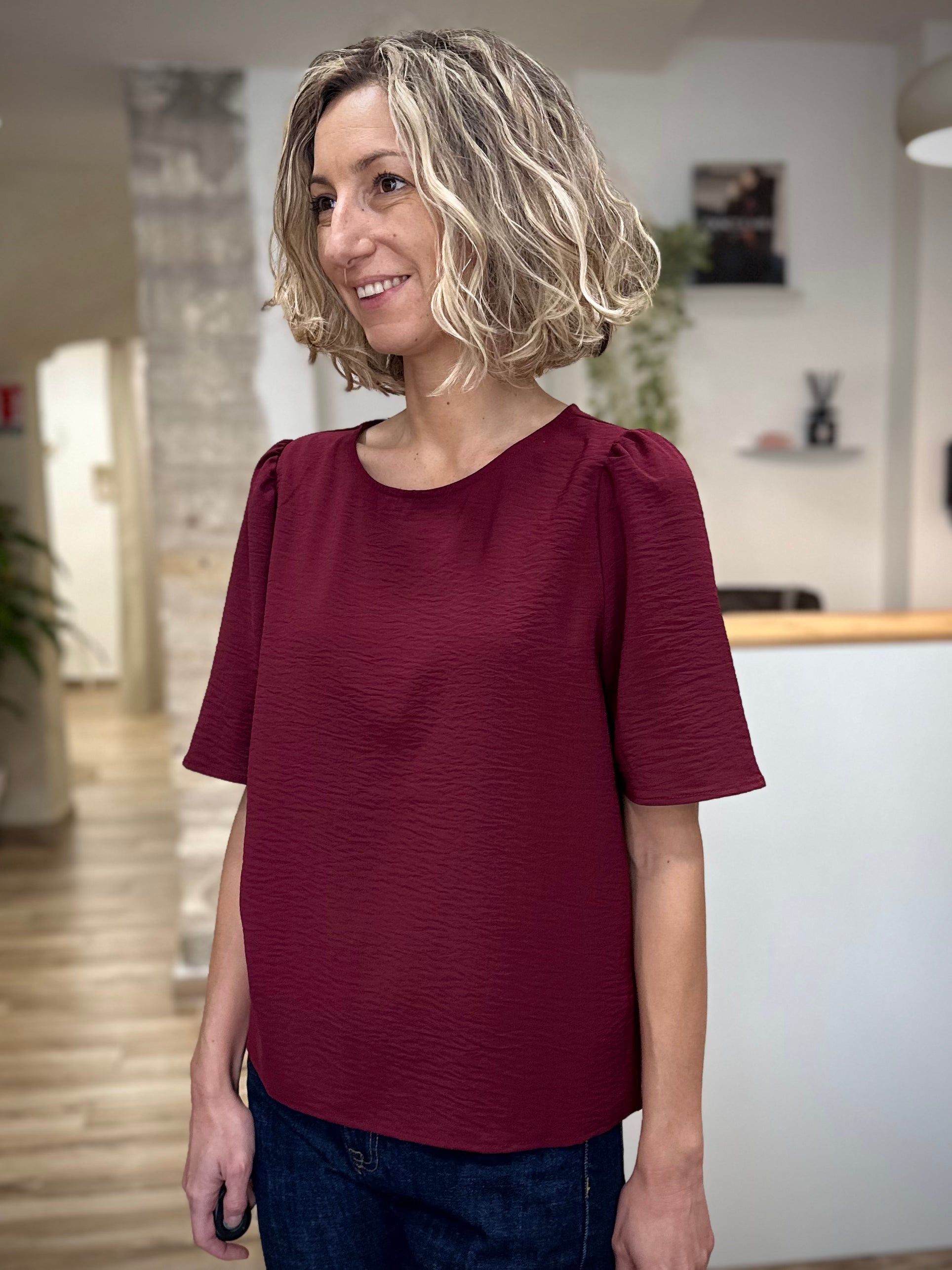 Femme souriante portant un top fluide col rond