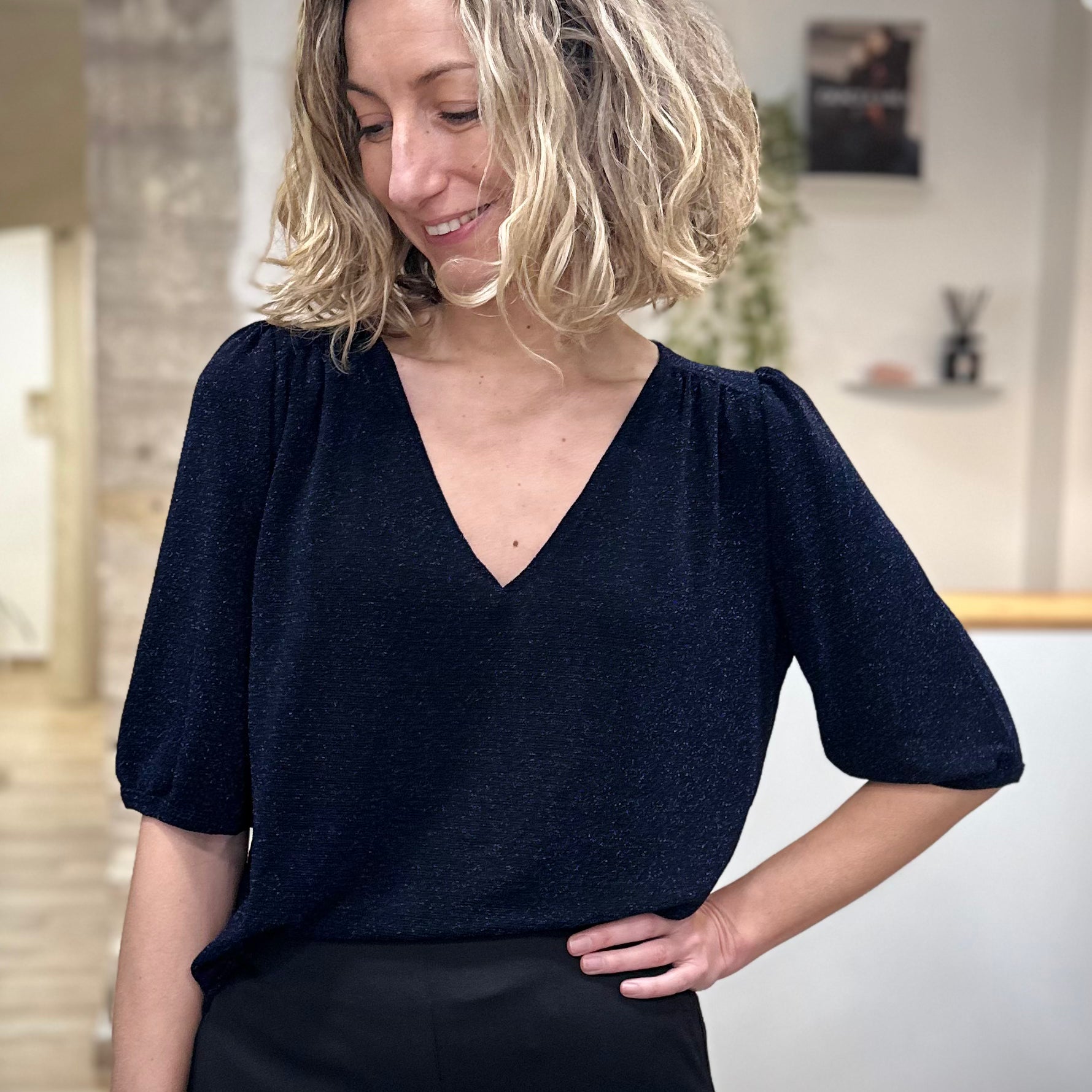 Femme portant un top marine scintillant en lurex