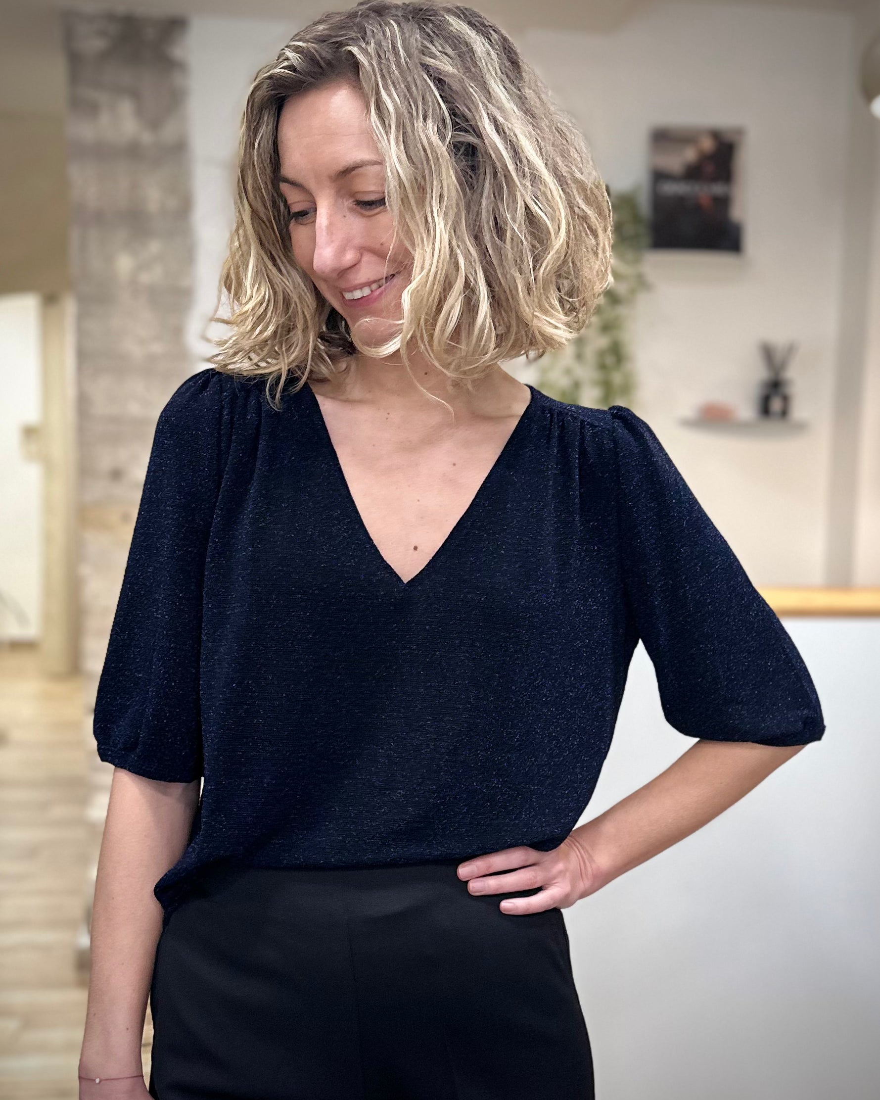 Femme portant un top marine scintillant en lurex