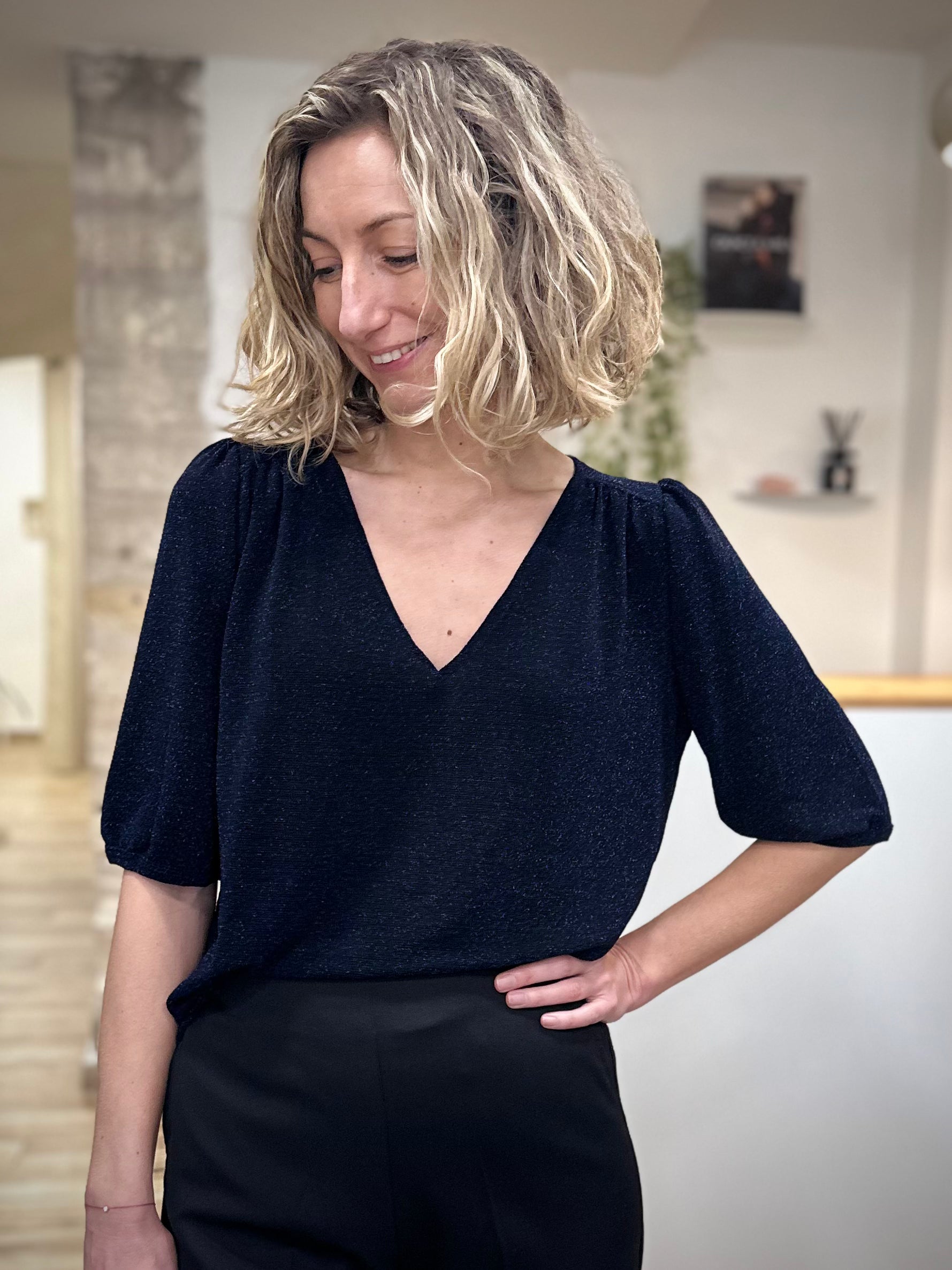 Femme portant un top marine scintillant en lurex