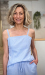Femme portant un top vichy bleu ciel ajusté en coton 