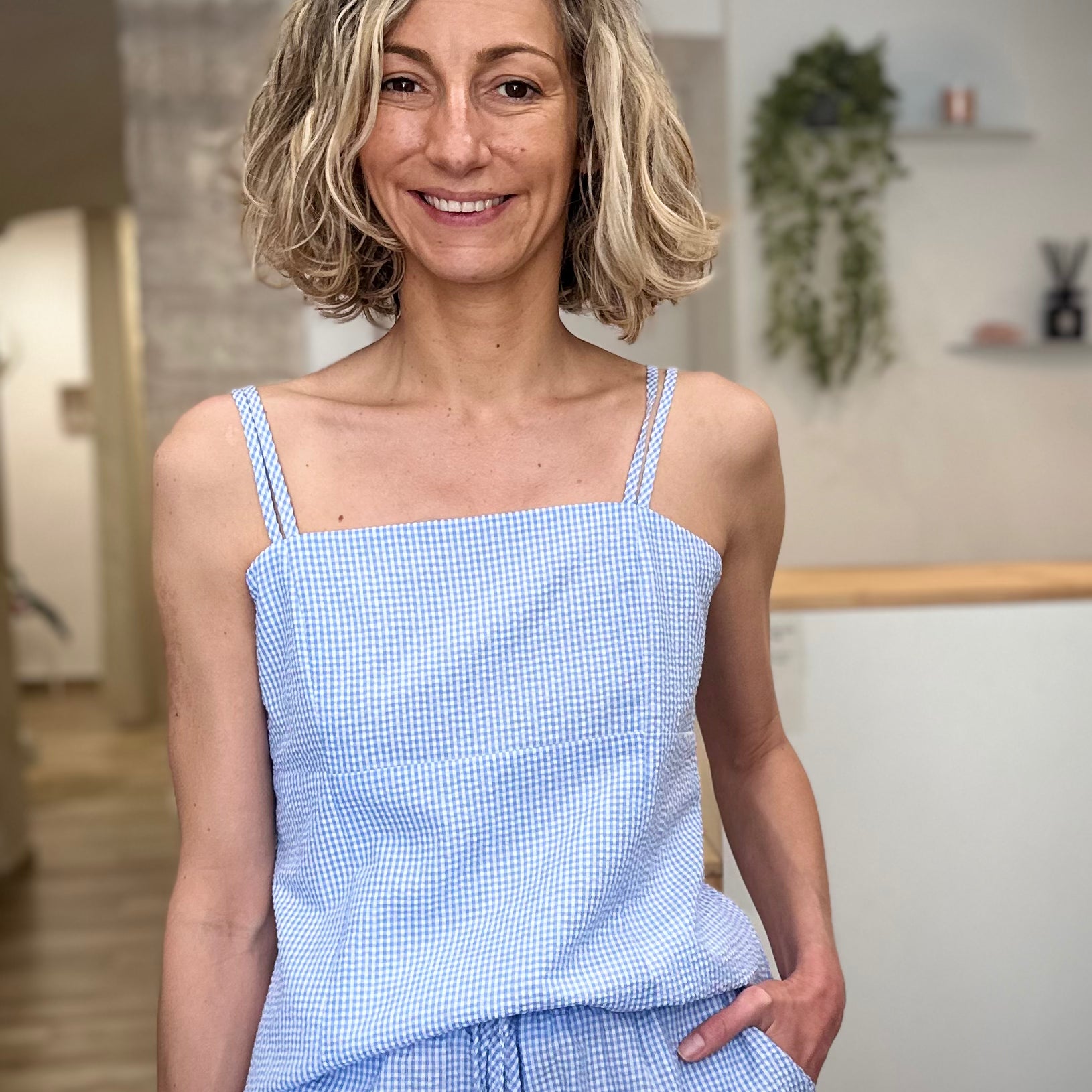 Femme portant un top vichy bleu ciel ajusté en coton 