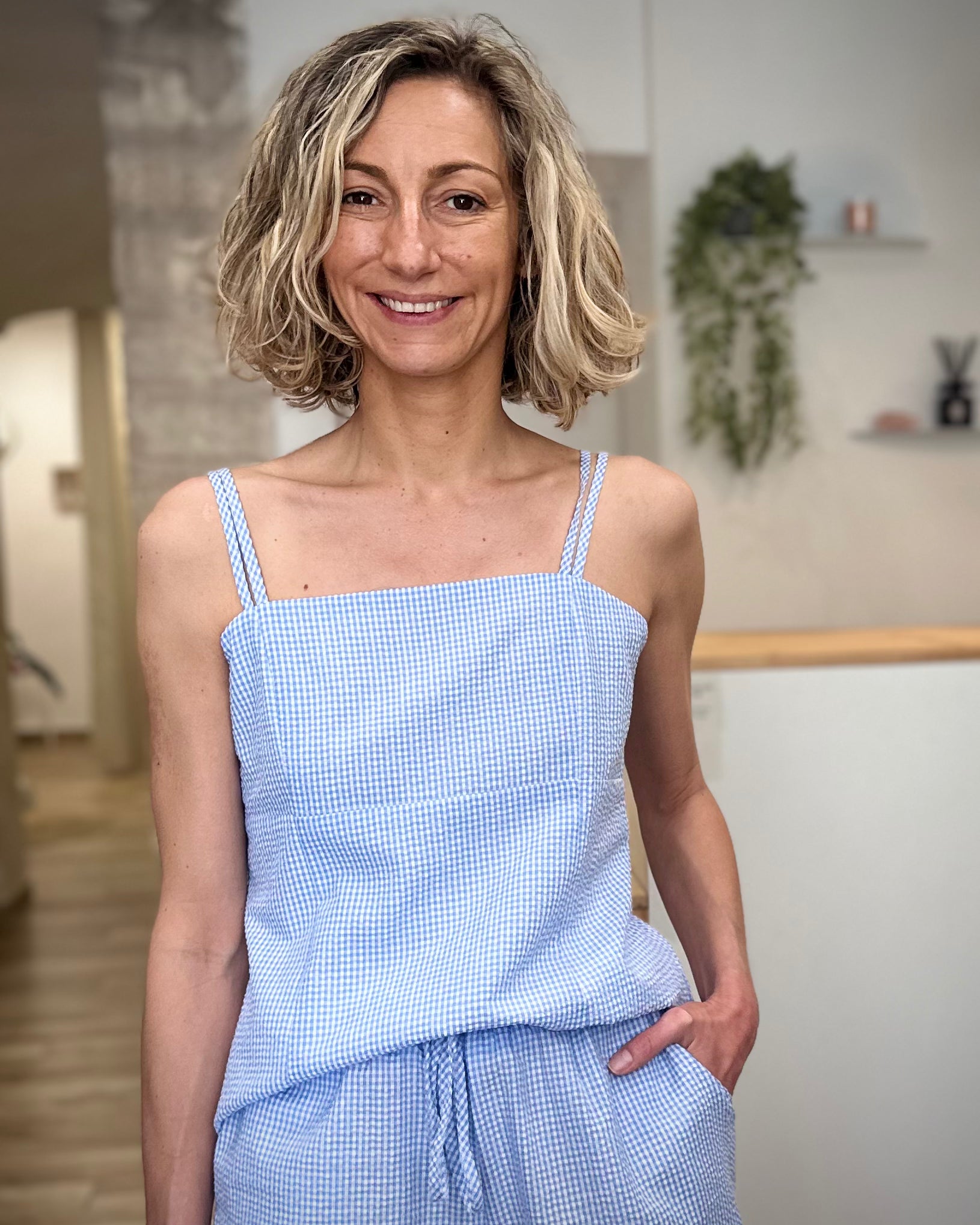 Femme portant un top vichy bleu ciel ajusté en coton 