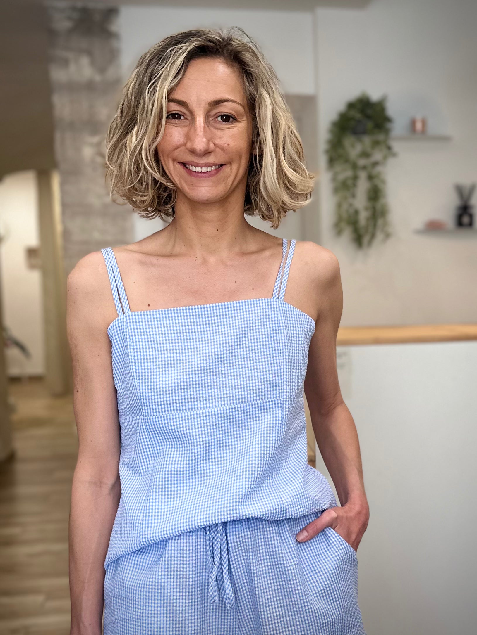 Femme portant un top vichy bleu ciel ajusté en coton 