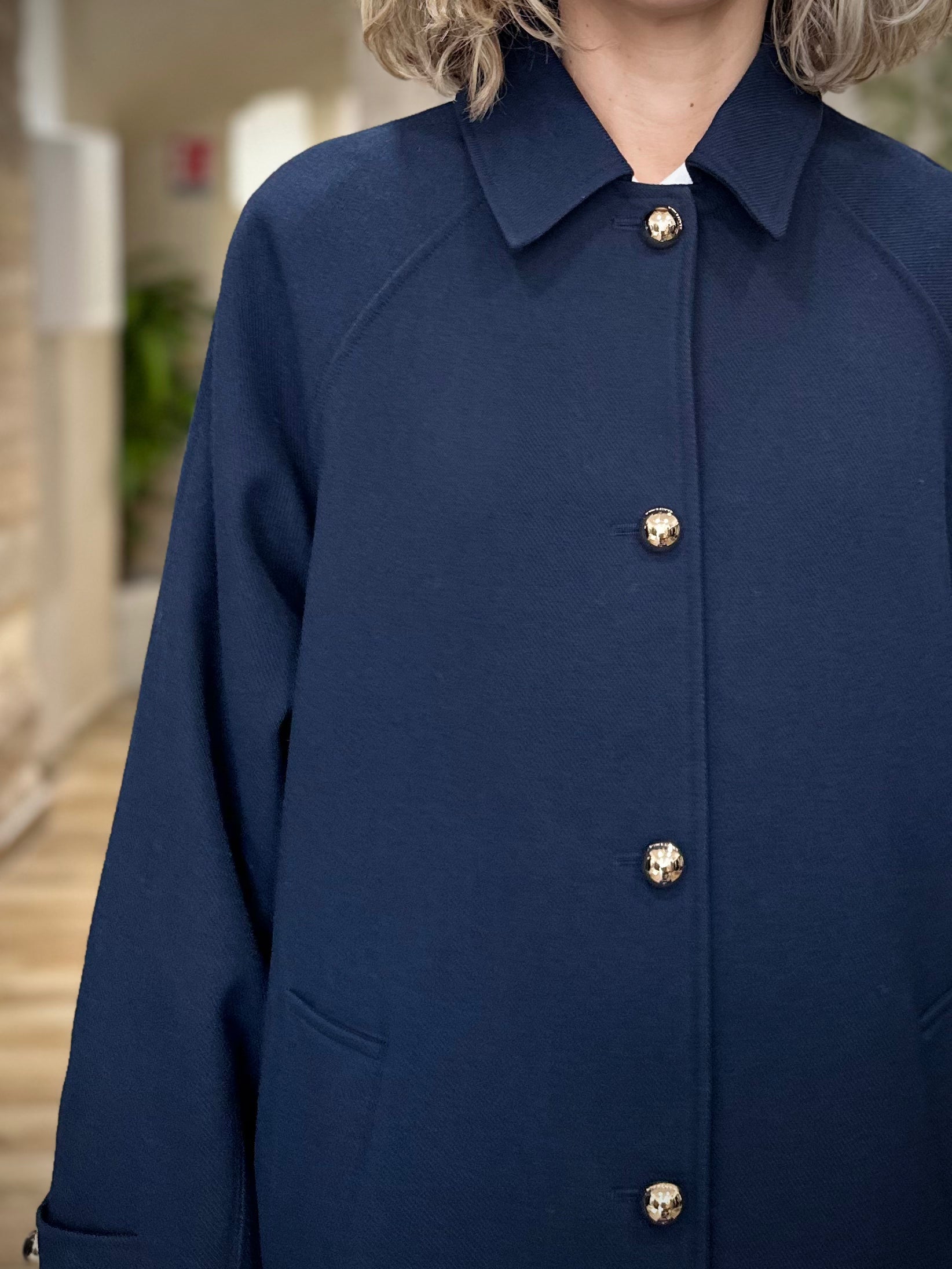 Détail des boutons dorés gravés sur trench long