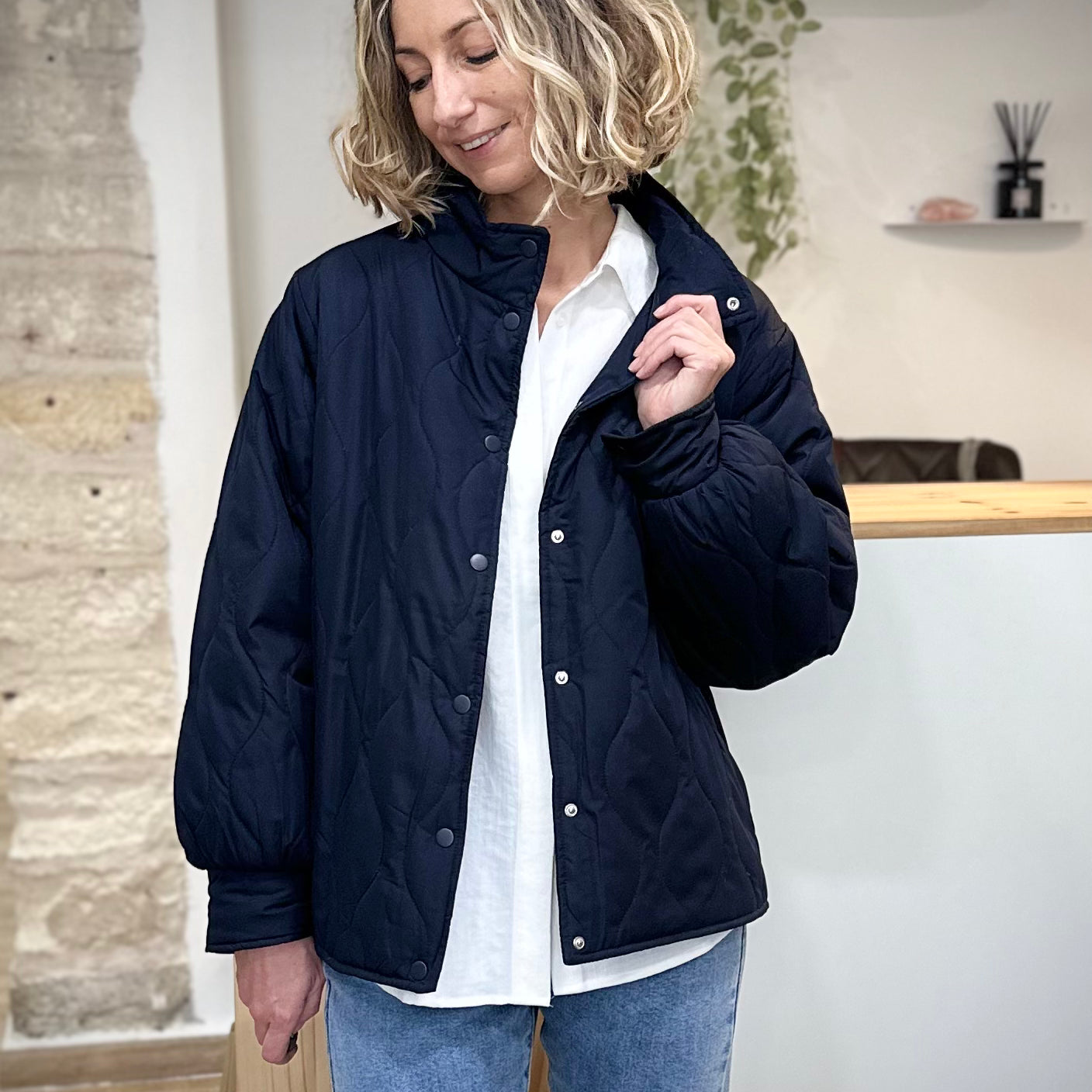 Femme portant une veste mi-saison bleu marine matelassée avec col montant