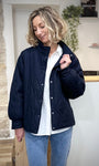 Femme portant une veste mi-saison bleu marine matelassée avec col montant
