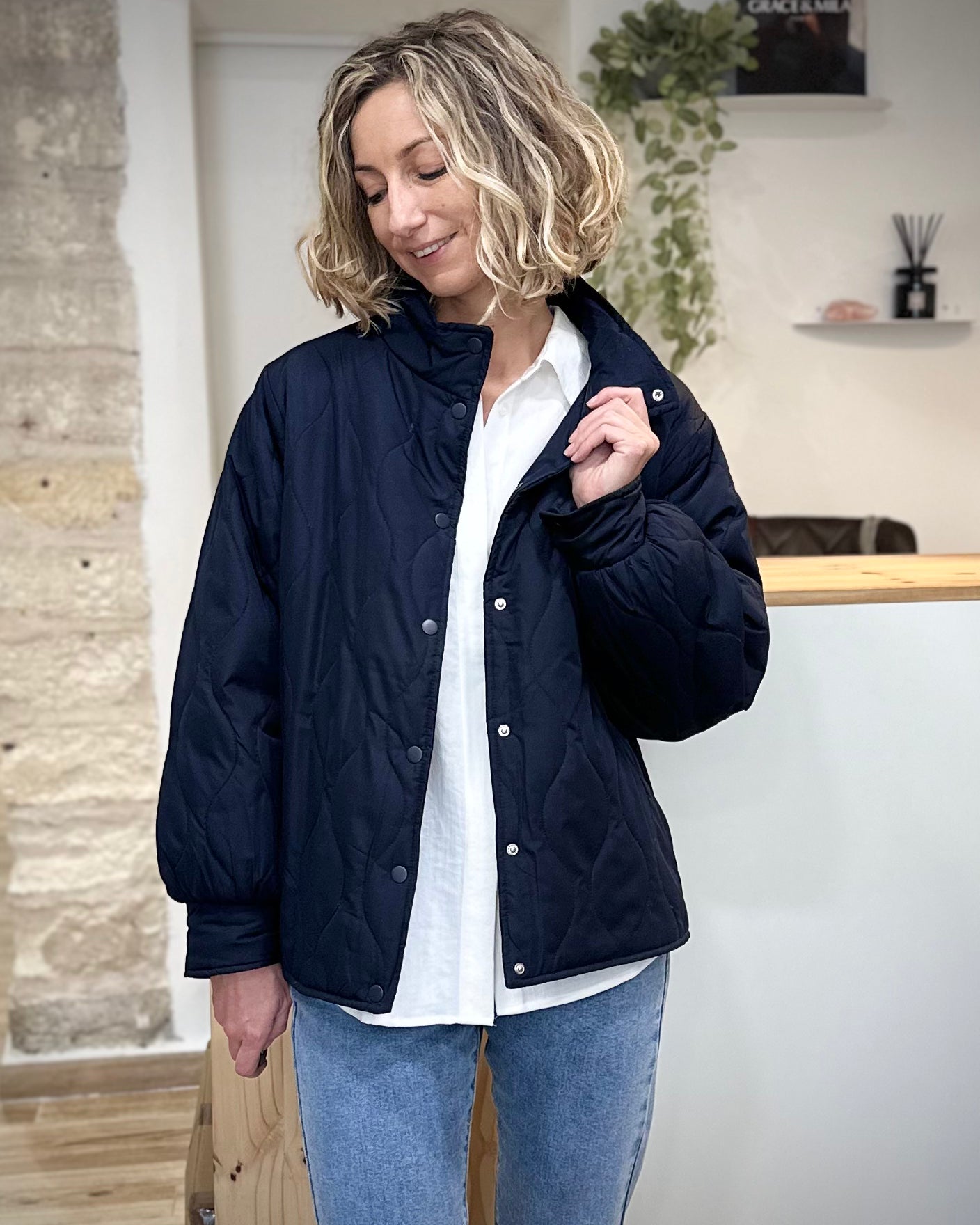 Femme portant une veste mi-saison bleu marine matelassée avec col montant