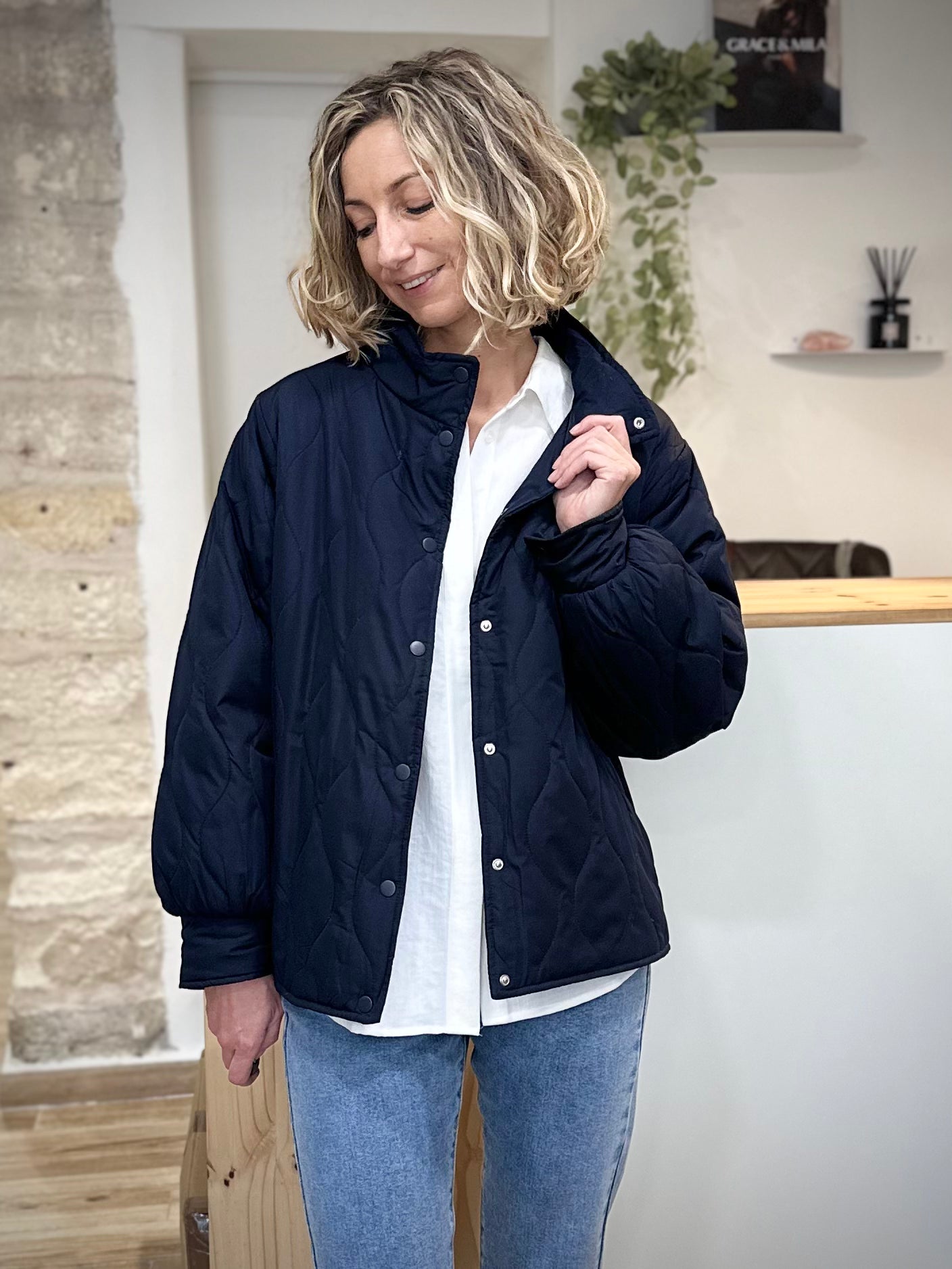 Femme portant une veste mi-saison bleu marine matelassée avec col montant
