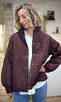 Femme portant une veste matelassée bordeaux avec col montant