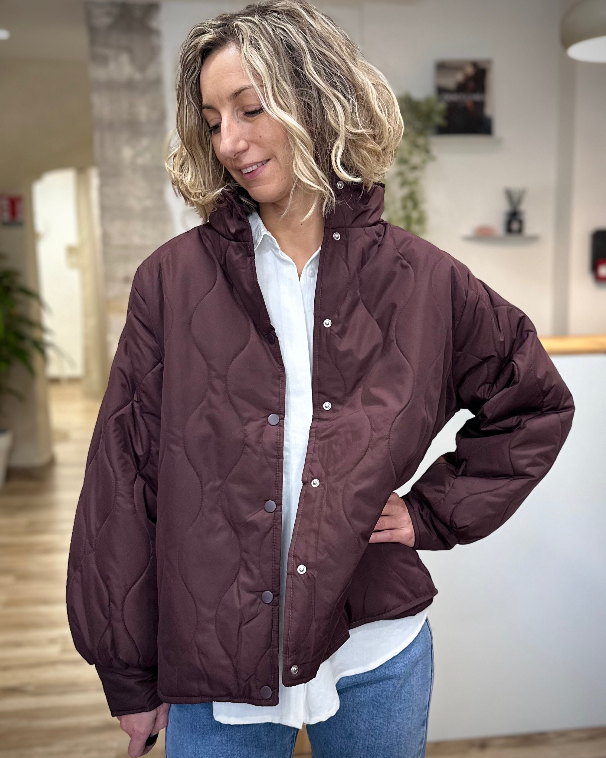 Femme portant une veste matelassée bordeaux avec col montant