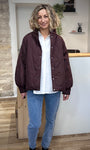 Femme souriante portant la veste mi-saison EGIA bordeaux