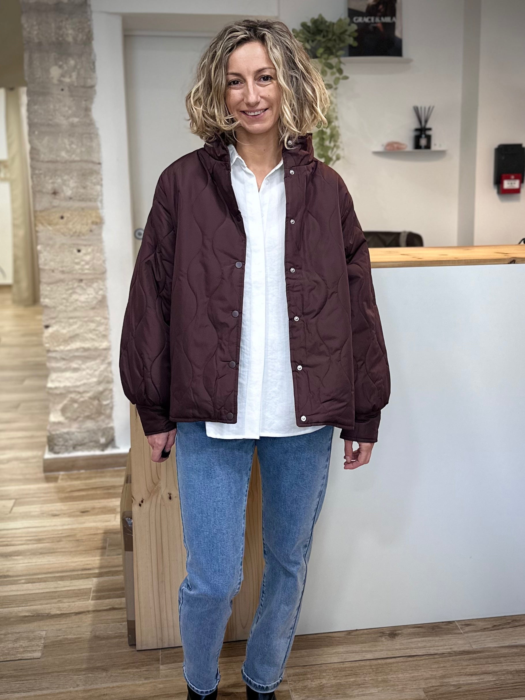 Femme souriante portant la veste mi-saison EGIA bordeaux