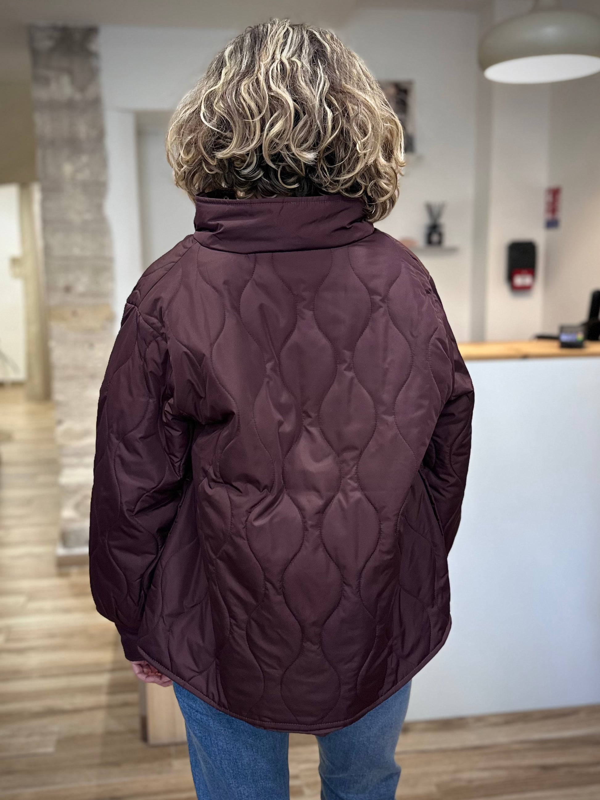 Vue de dos d’une femme portant la veste EGIA bordeaux