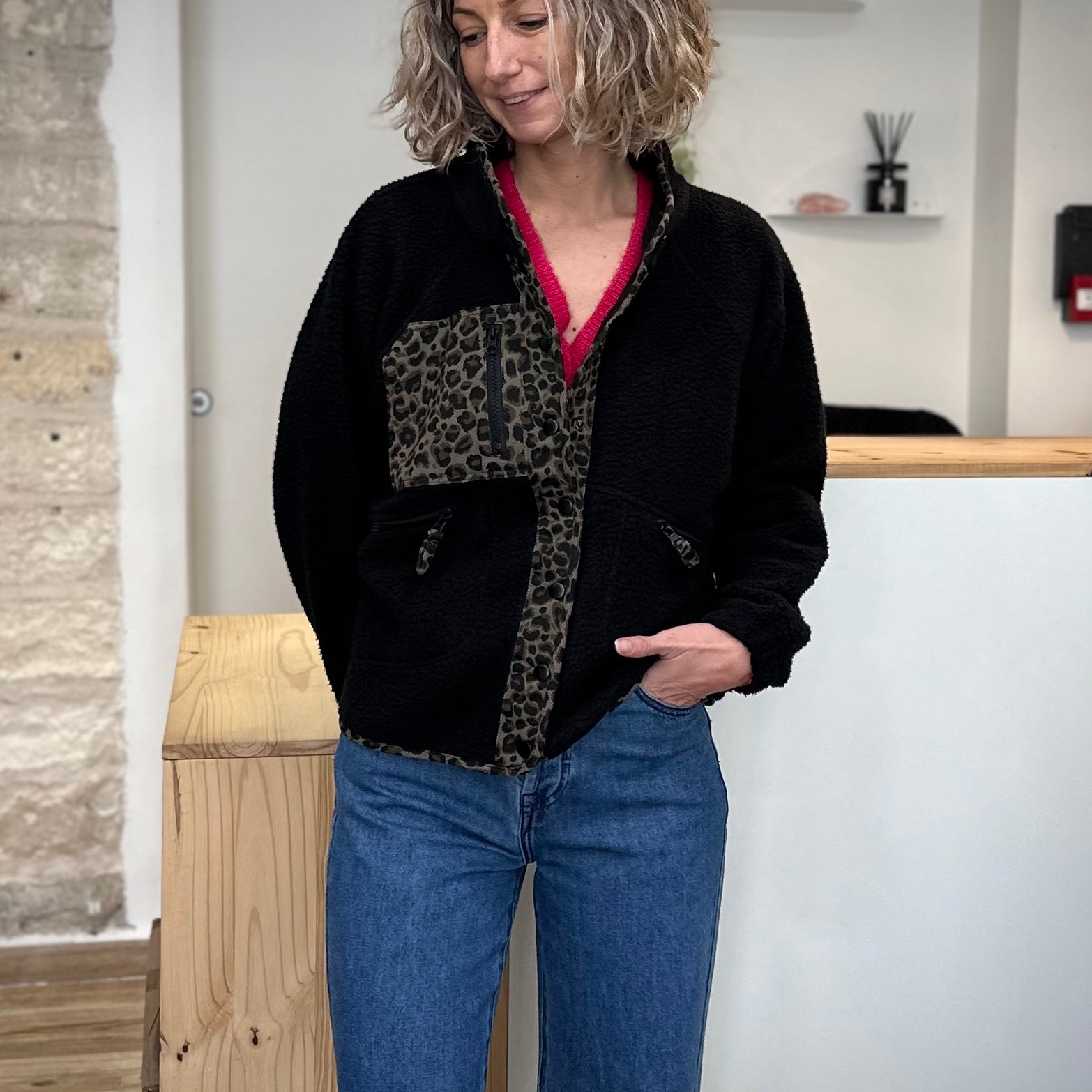 Femme portant une veste polaire noire avec détails léopard
