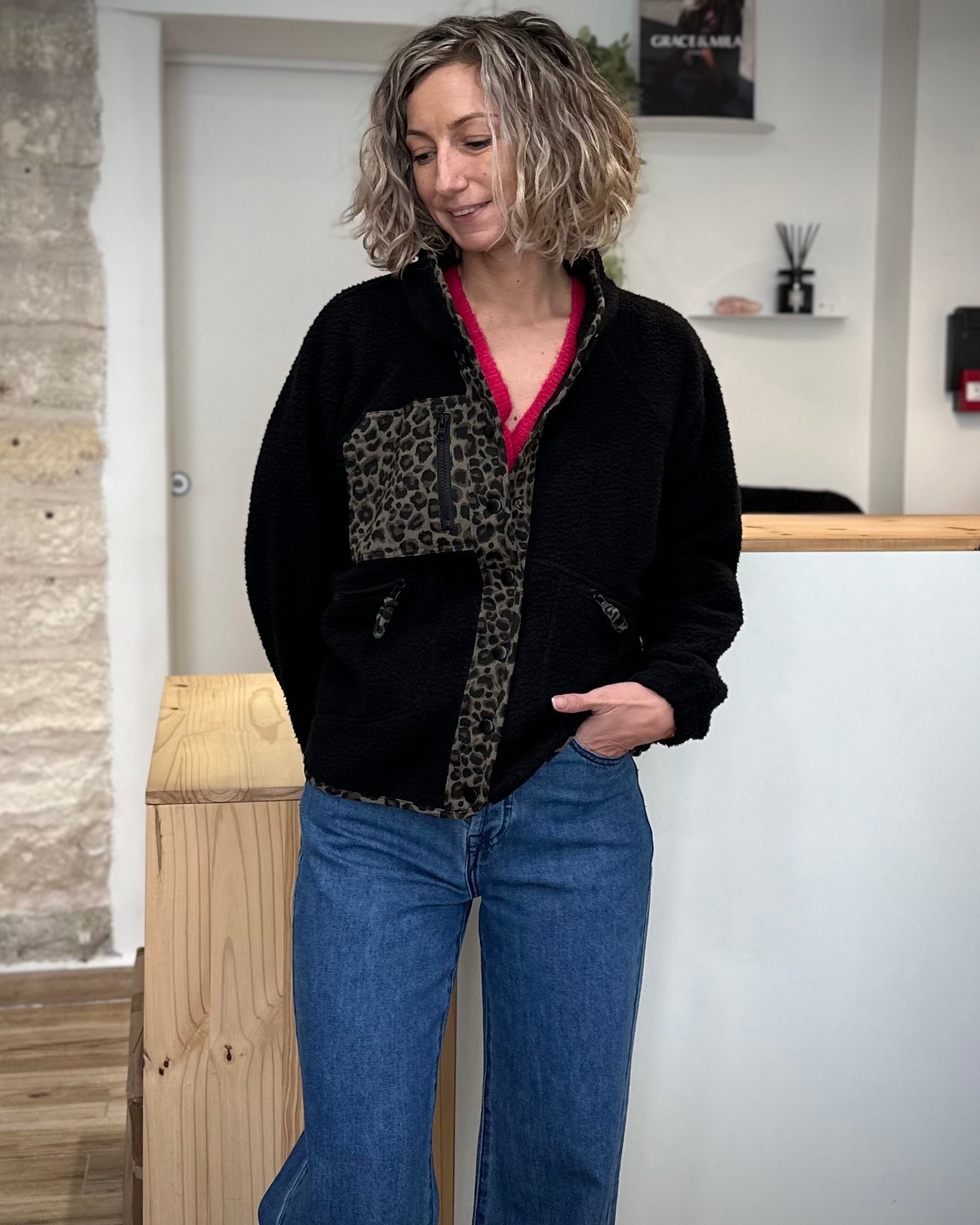 Femme portant une veste polaire noire avec détails léopard