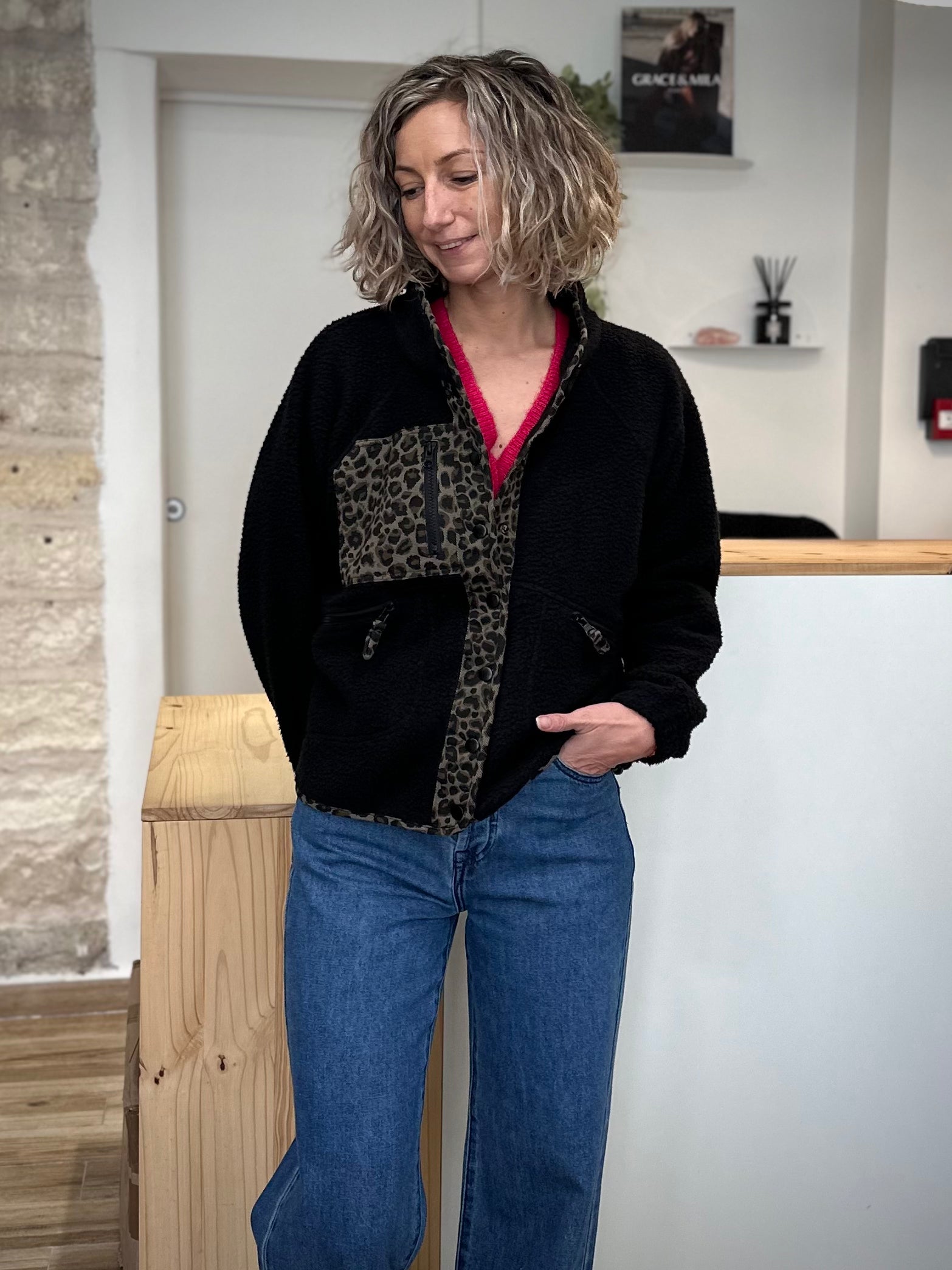 Femme portant une veste polaire noire avec détails léopard