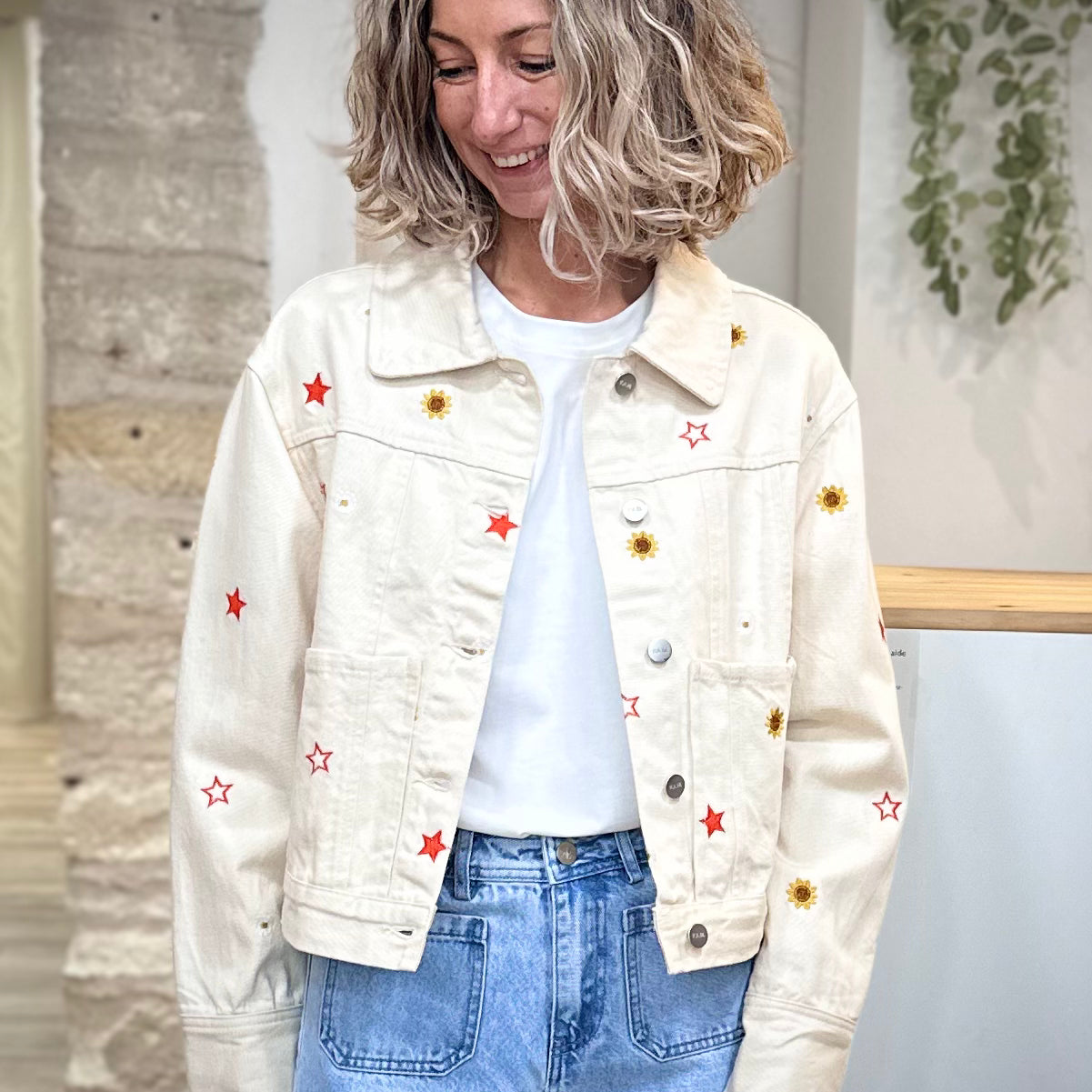 Femme portant veste en jean écru brodée