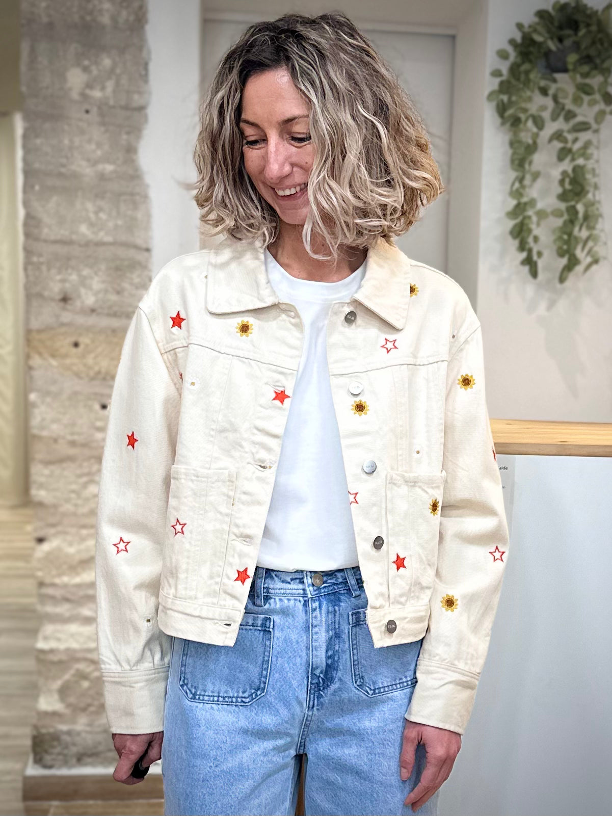 Femme portant veste en jean écru brodée