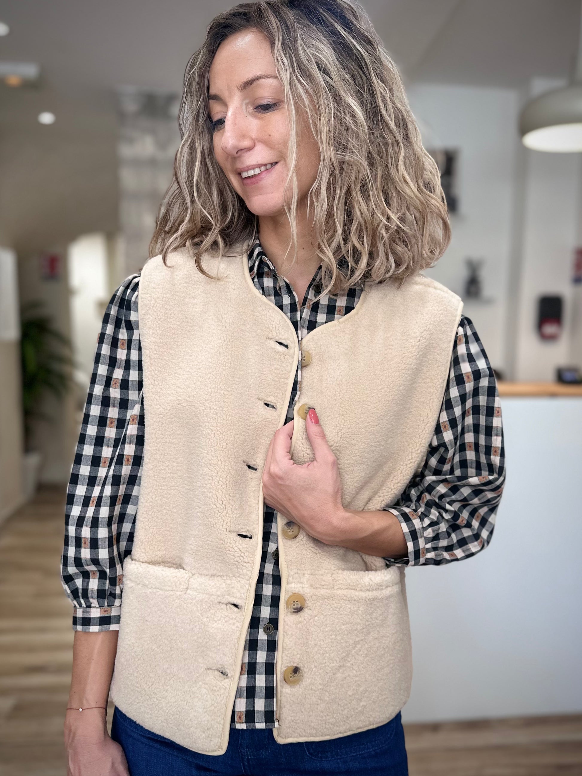 Détail boutonnière veste sans manches beige femme