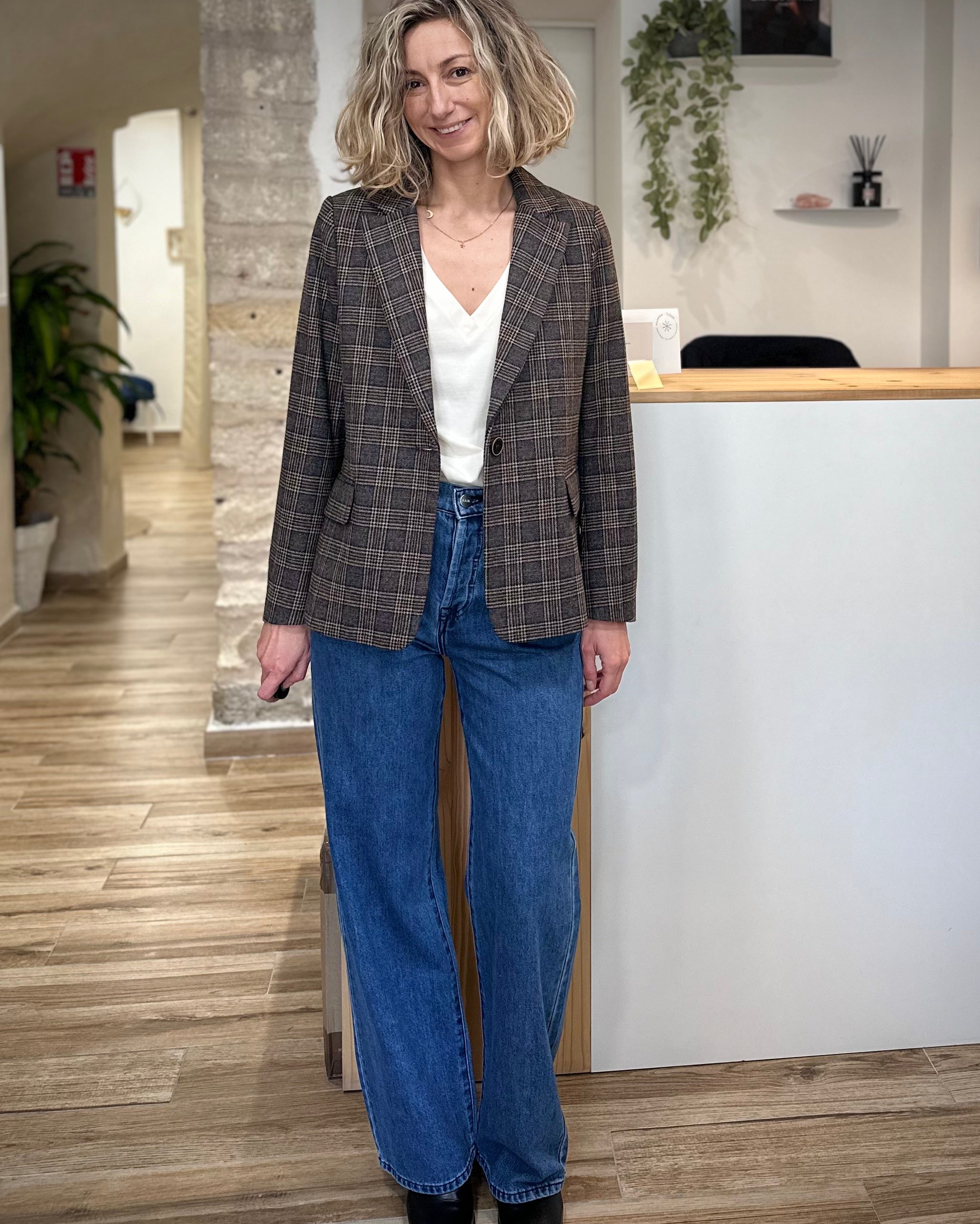 Femme portant une veste blazer à carreaux gris et beige