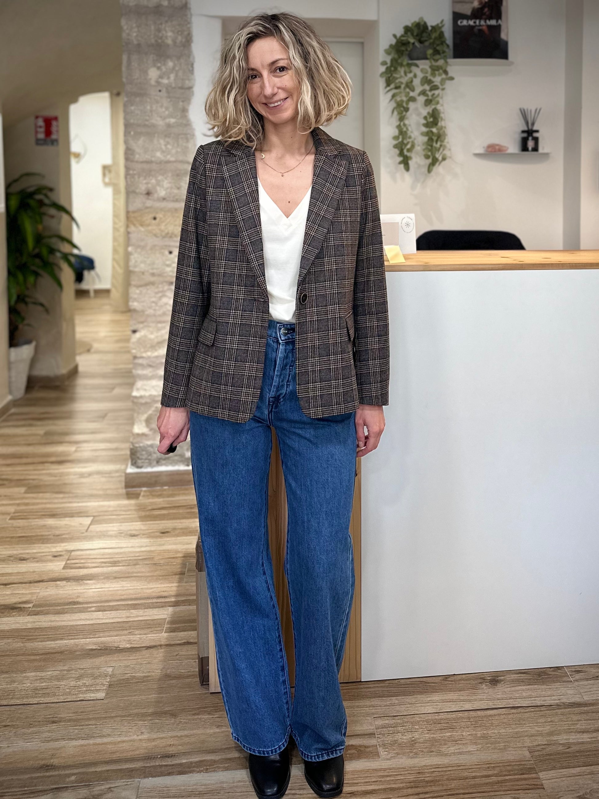 Femme portant une veste blazer à carreaux gris et beige