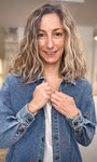 Zoom sur la forme liquette d’une veste en jean brodée