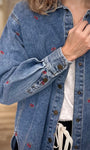 Détail des poignets boutonnés d’une veste en jean oversize