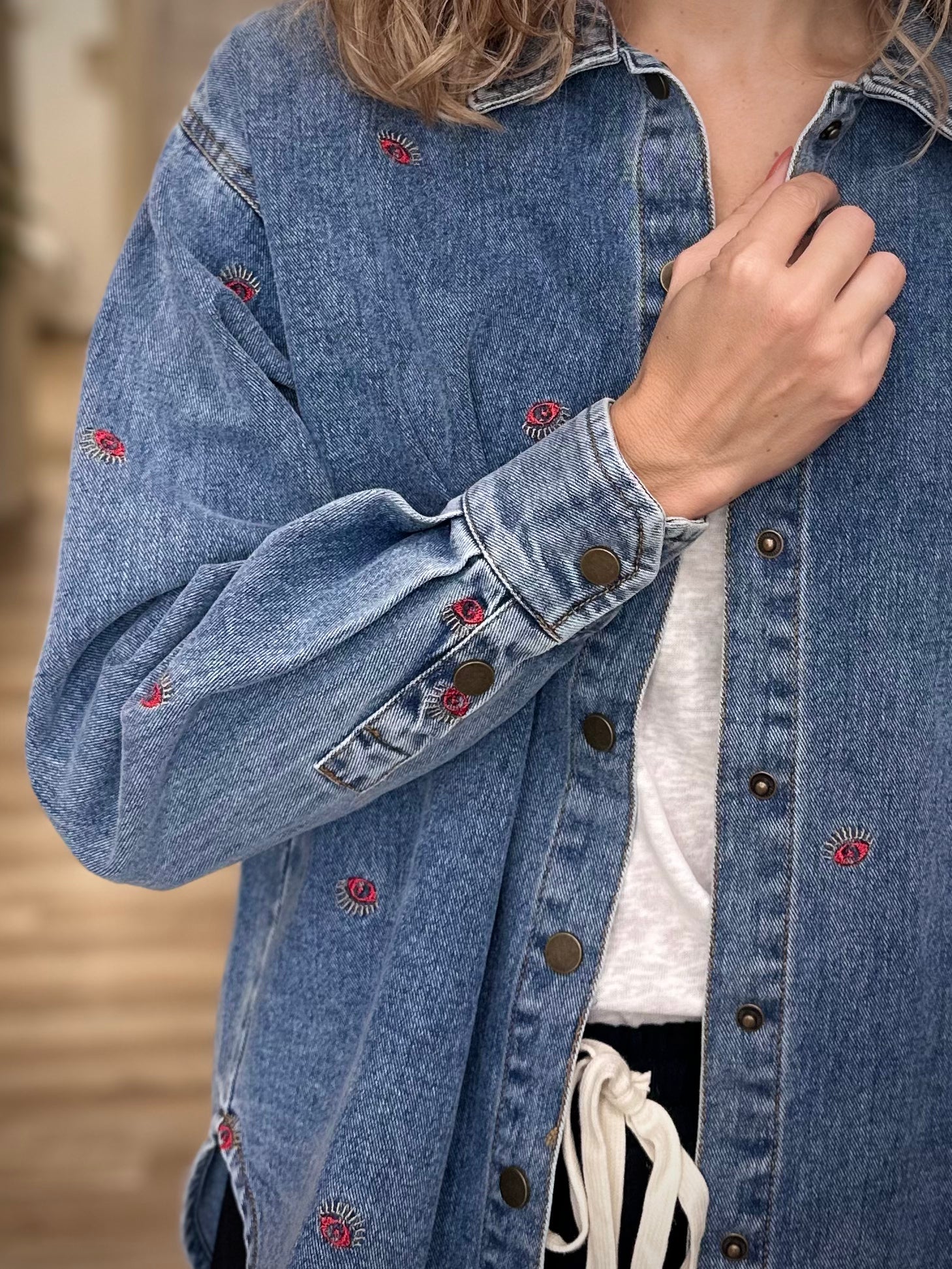 Détail des poignets boutonnés d’une veste en jean oversize