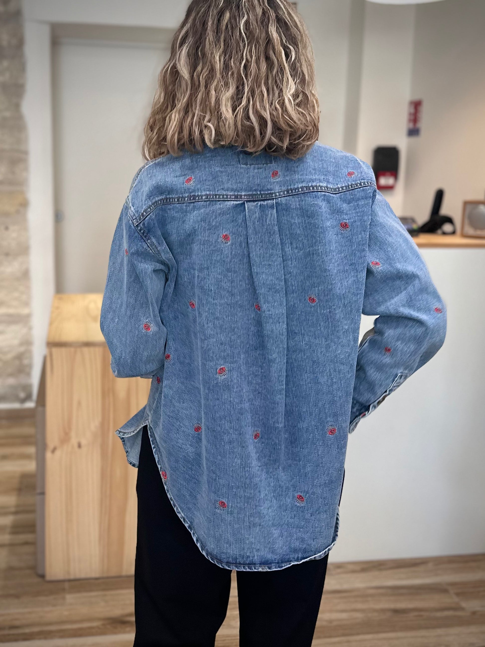 Dos d’une veste denim brodée avec plis d’aisance
